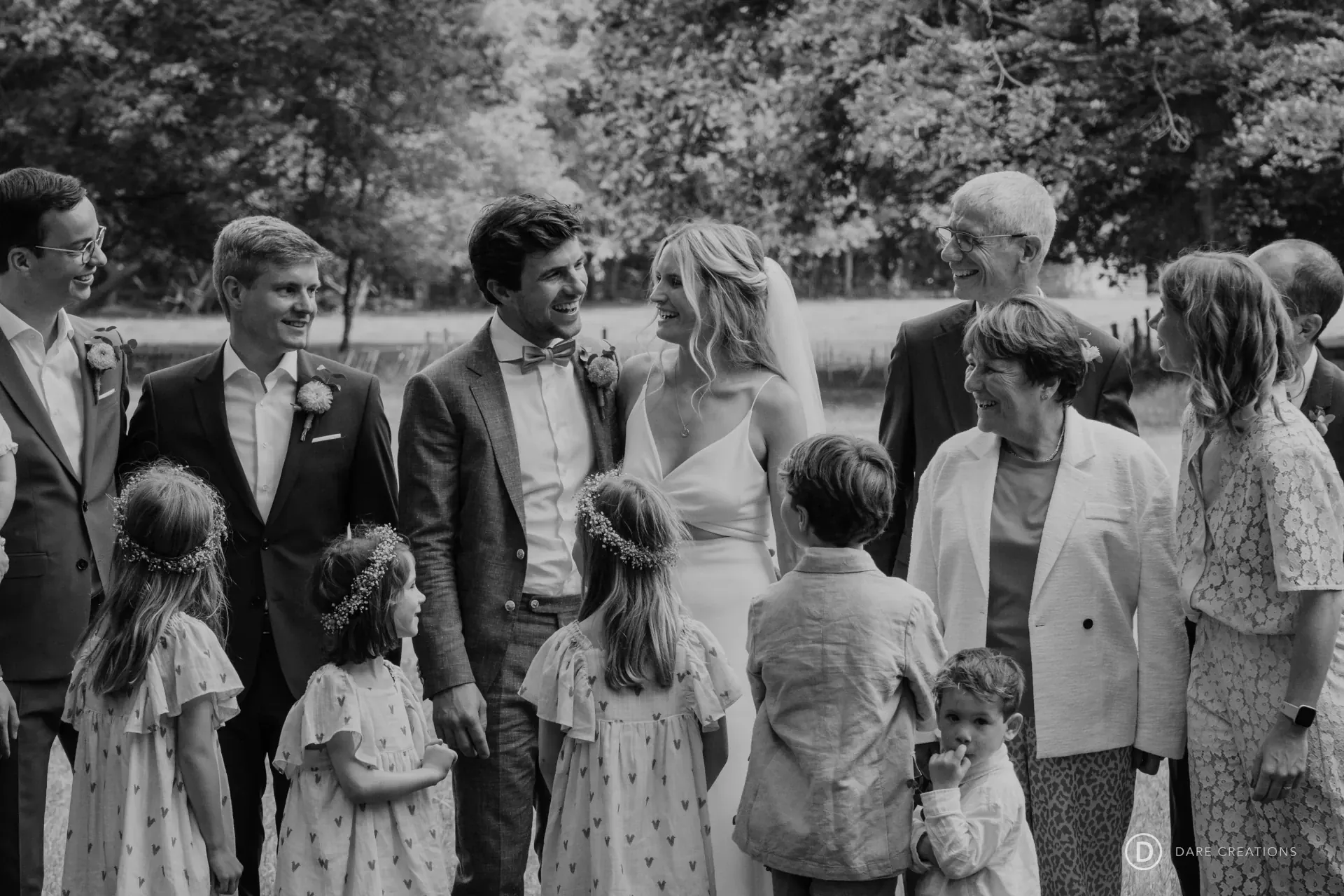 Familie van het getrouwde koppel kijkt naar het koppel terwijl zij rond hen staan.